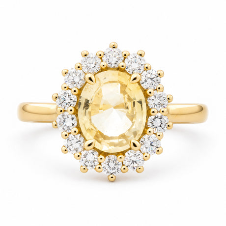 An antique-inspired, pale yellow sapphire and diamond cluster engagement ring set in 14ct yellow gold. 