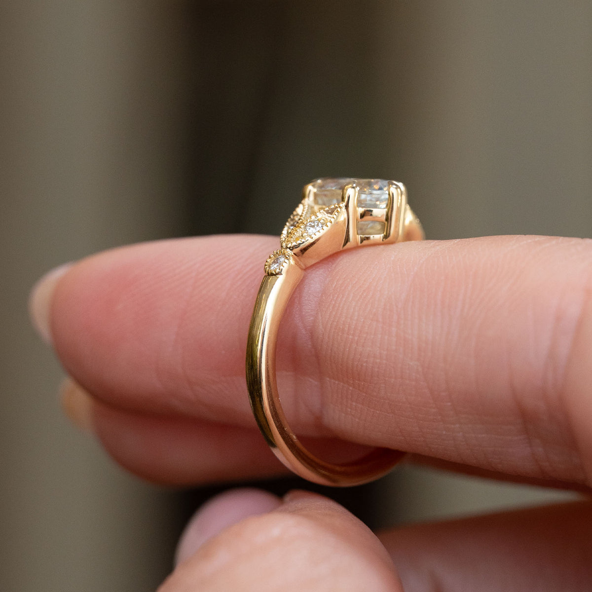 Side profile of the yellow gold engagement ring, showing the raised basket setting and gracefully tapered shoulders.