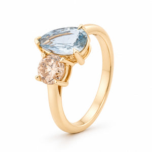 Angled view of the toi et moi ring, highlighting the contrasting gemstones, delicate claw settings and polished yellow gold band.