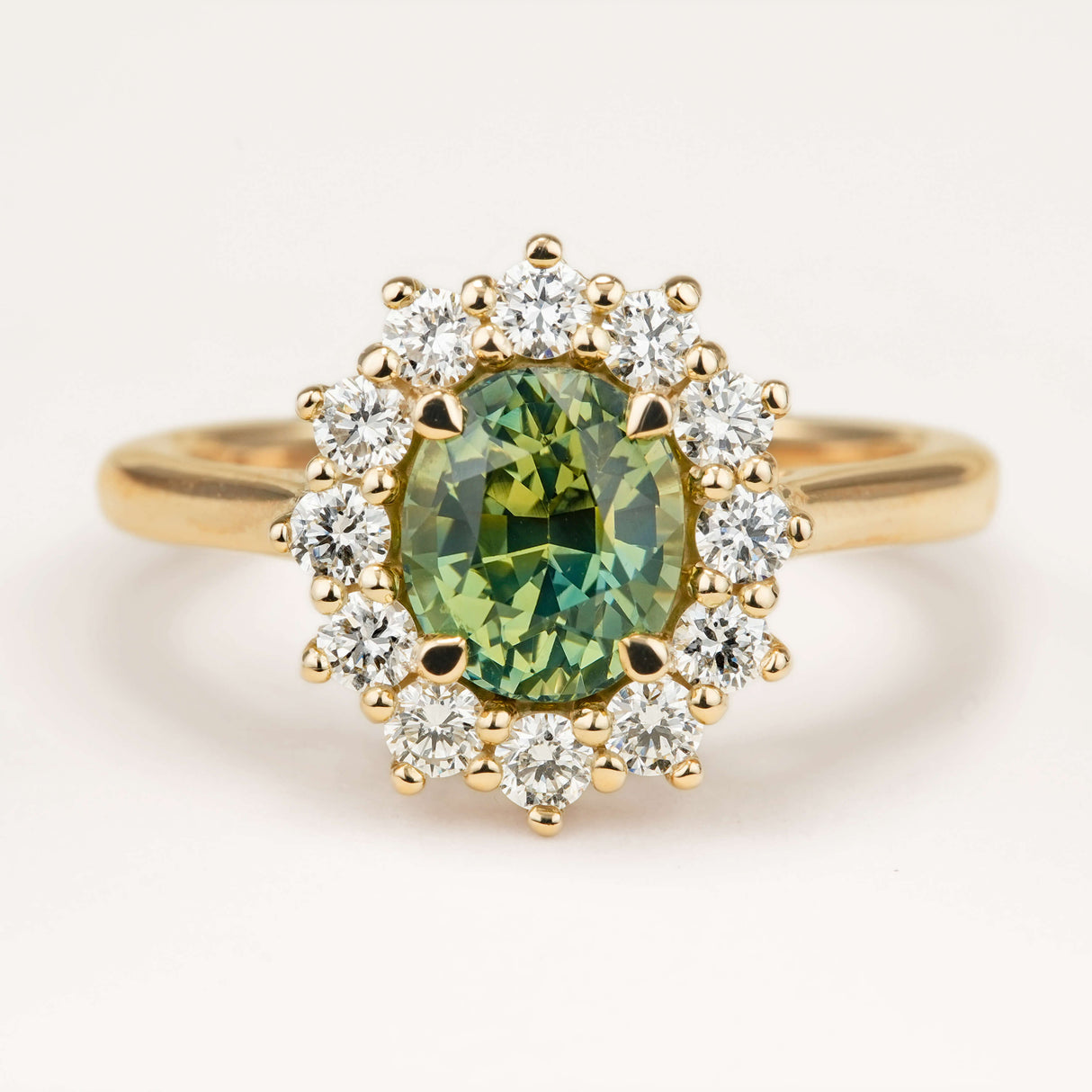 Oval-cut Green sapphire and diamond cluster engagement ring