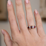 Antique ruby and diamond engagement ring worn on the hand, showing the bold proportions of its Victorian three-stone design.