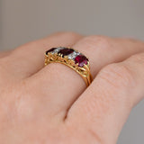 Low side angle of the Victorian ring being worn, revealing the raised gemstones and decorative pierced gold gallery.