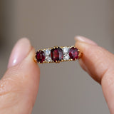 Handheld close-up of the ruby and old-cut diamond engagement ring, displaying its richly coloured stones and antique craftsmanship.