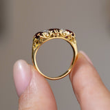 Profile view of the Victorian three-stone ring, showing the intricate scrolling gallery and polished yellow gold shank.