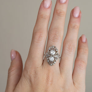 A striking antique diamond cocktail ring worn on a hand, showcasing its elongated geometric shape and delicate platinum craftsmanship.