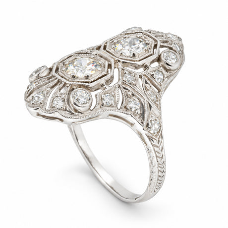 Angled studio photograph of the Art Deco diamond ring, revealing intricate openwork platinum detailing and an ornate raised setting.