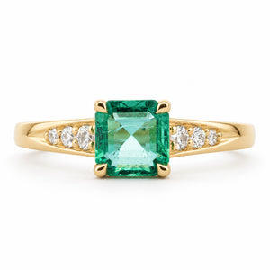 Vintage-inspired, Emerald and diamond flanked solitaire engagement ring with white background
