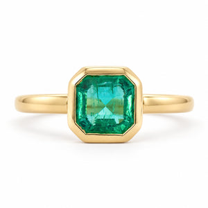 Antique-inspired, Emerald solitaire engagement ring on a white background