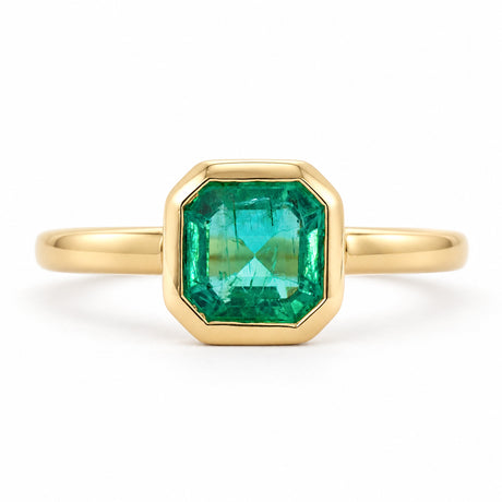 Antique-inspired, Emerald solitaire engagement ring on a white background