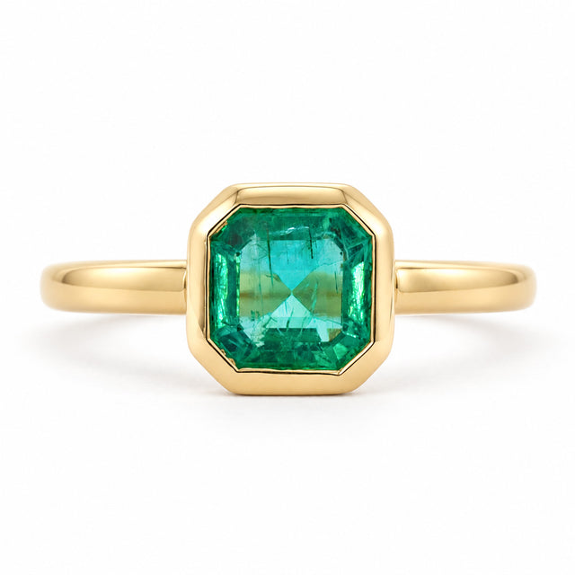 Antique-inspired, Emerald solitaire engagement ring on a white background