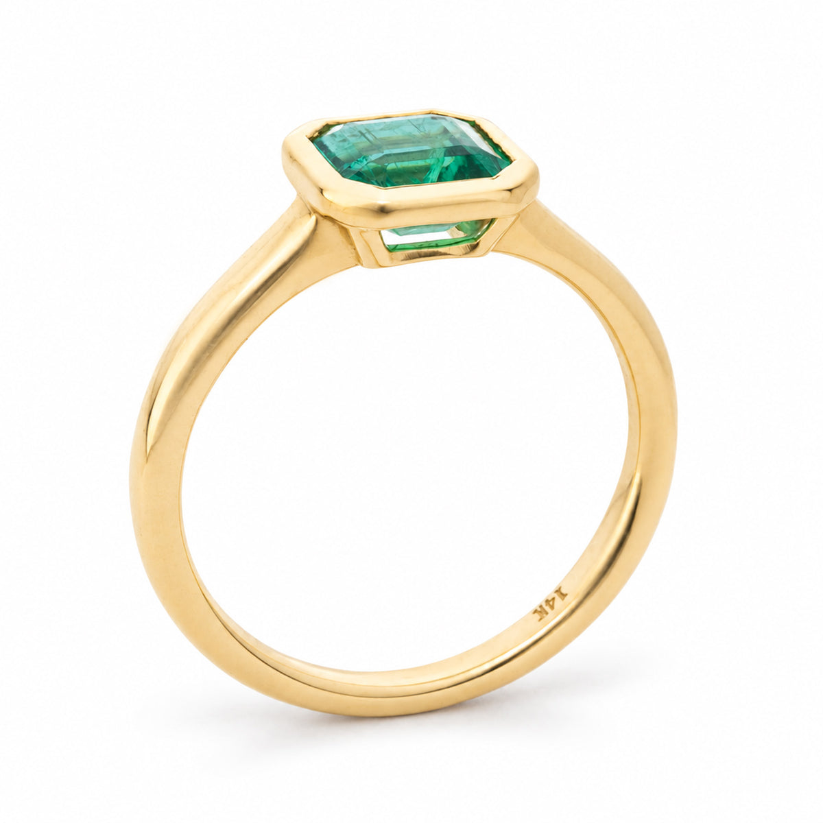 Antique-inspired, Emerald solitaire engagement ring from the side on white background