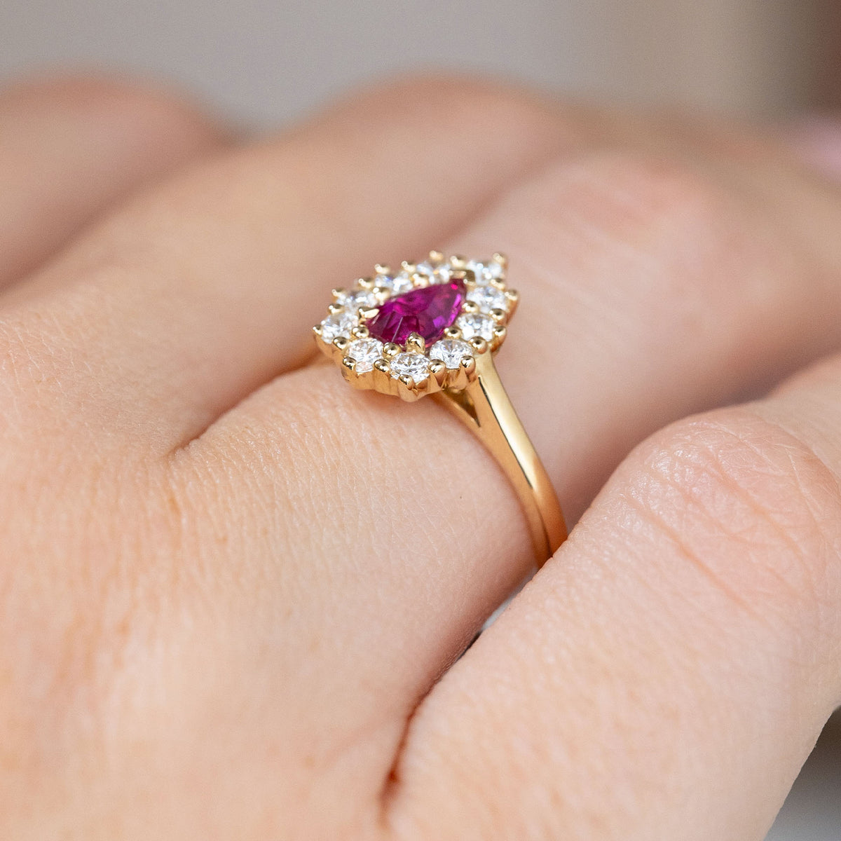 Three-quarter hand view highlighting the raised diamond cluster and graceful yellow gold shoulders.