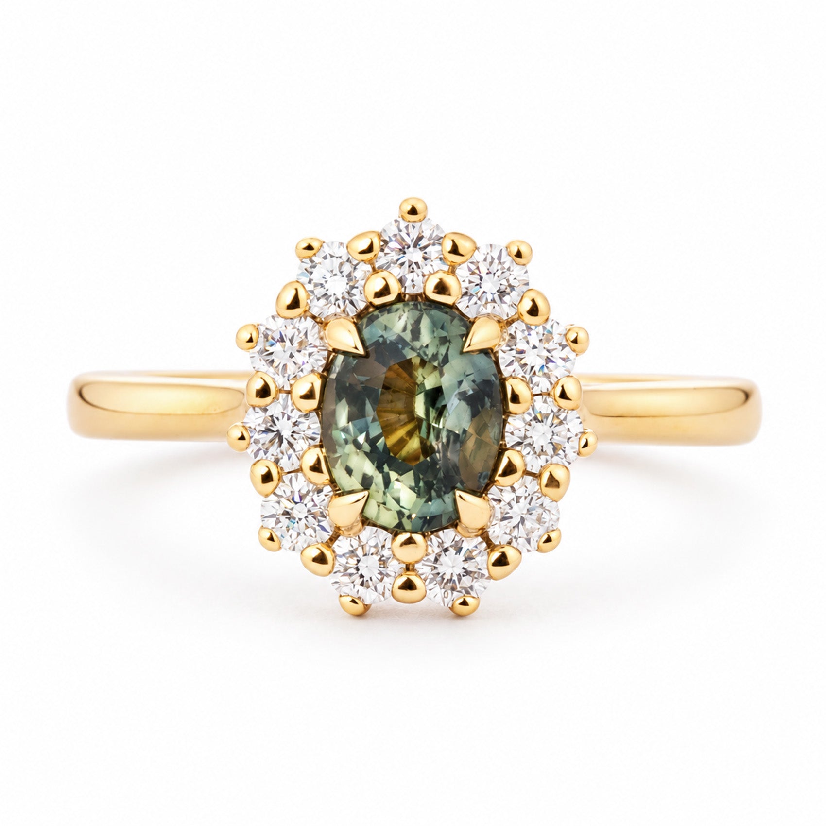 Antique-inspired engagement ring centred with a deep pine green sapphire and encircled by a halo of round diamonds in yellow gold.