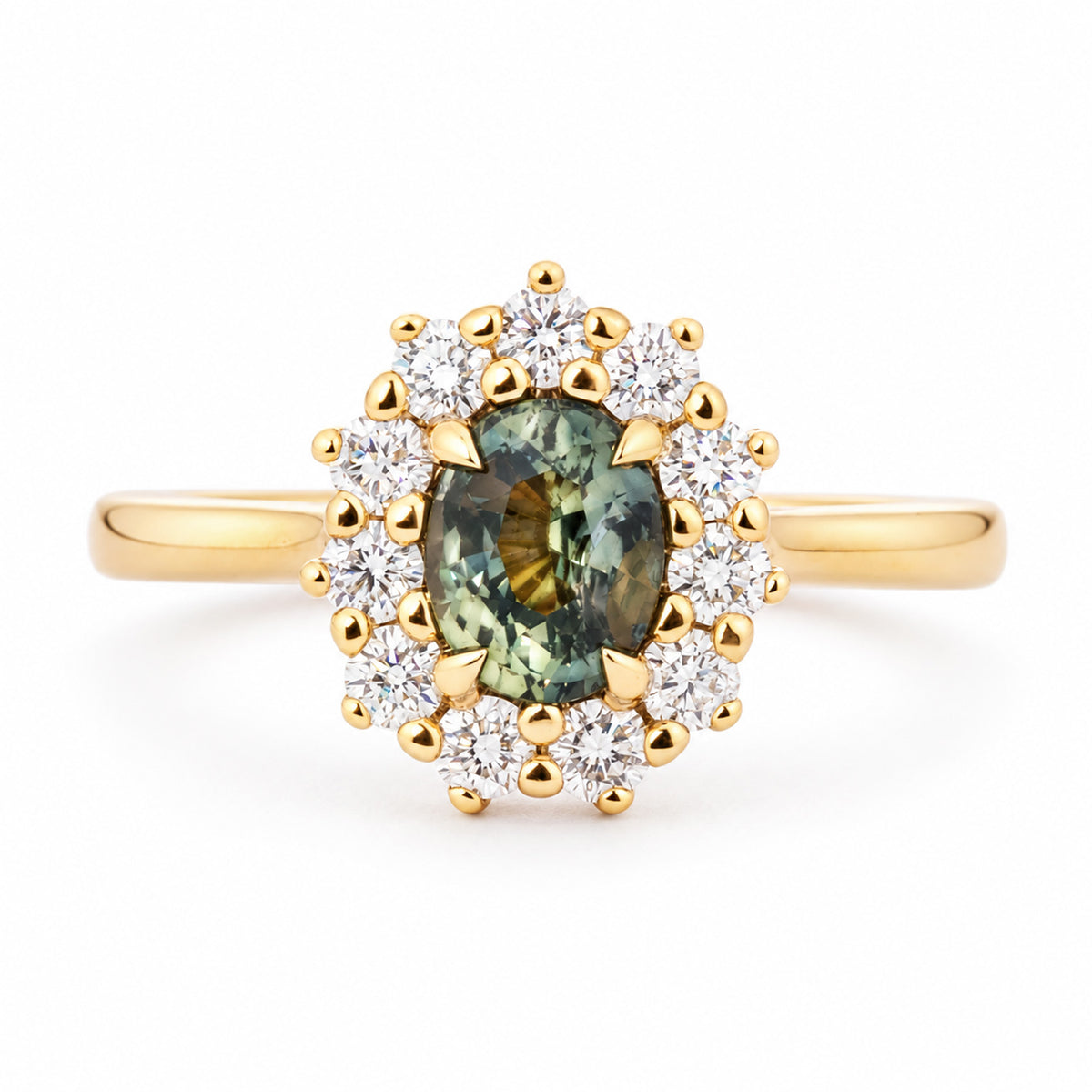 Antique-inspired engagement ring centred with a deep pine green sapphire and encircled by a halo of round diamonds in yellow gold.