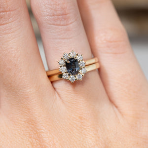 Blue sapphire cluster engagement ring paired with a yellow gold wedding band, showcasing its wed-fit design and how the two rings sit together.
