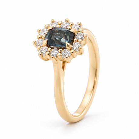 Angled view of the blue sapphire cluster ring, highlighting the raised claw setting and sparkling diamond halo.
