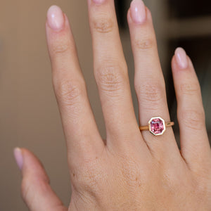 Peachy pink sapphire ring worn on the hand, displaying its elegant scale and warm vintage-inspired colour palette.