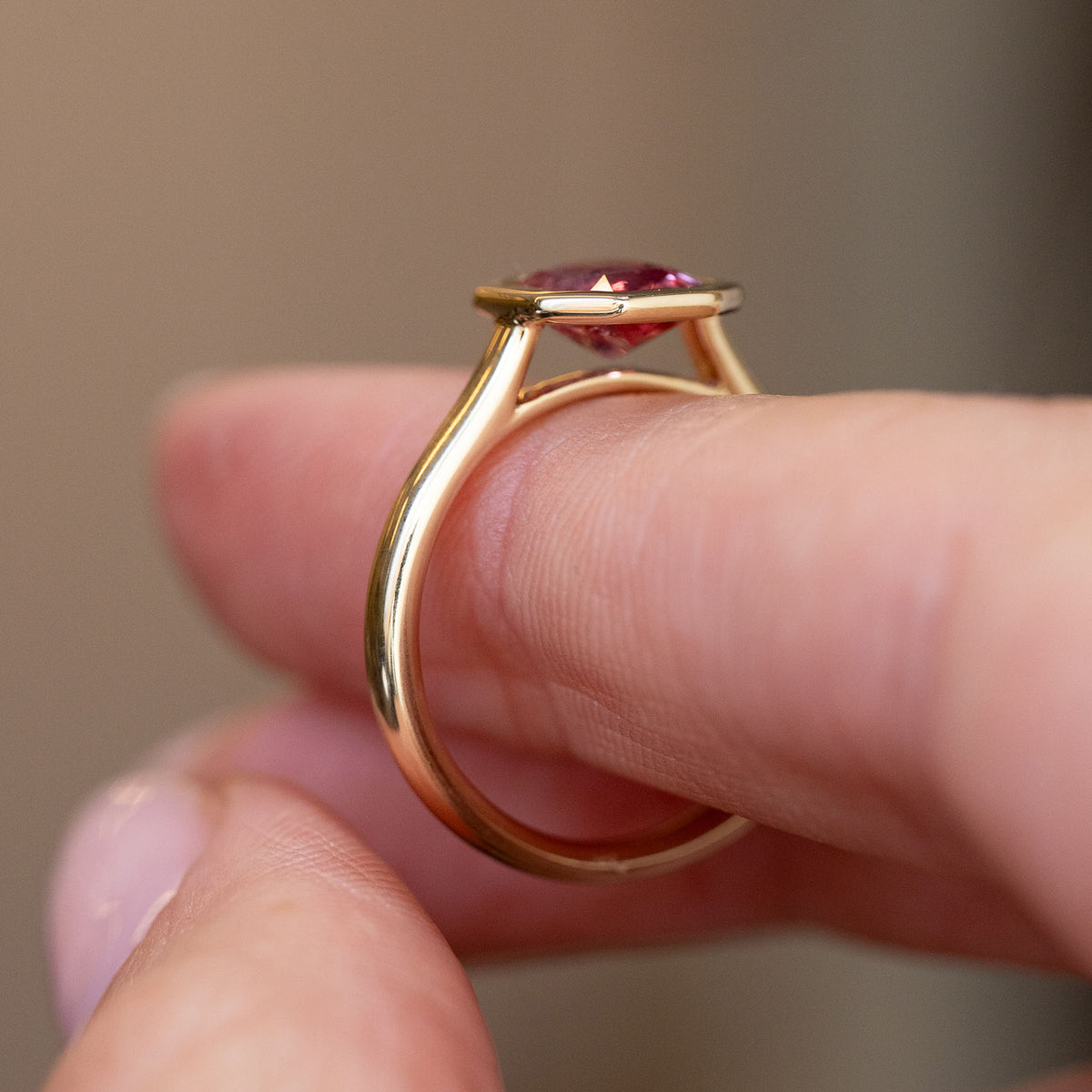 Side profile of the yellow gold ring, showing the open gallery and low, refined solitaire setting.
