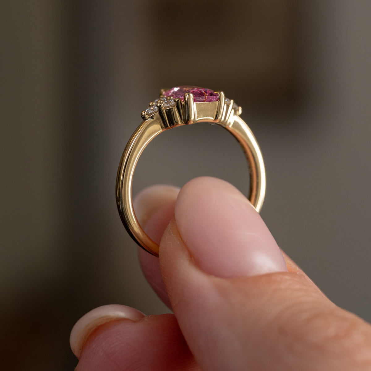Profile view of the vintage-inspired ring, displaying the elevated claw setting, diamond shoulders and slender gold shank.