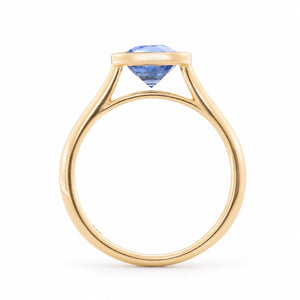 Side profile of the blue sapphire solitaire ring, highlighting the raised bezel setting and open gallery in yellow gold.