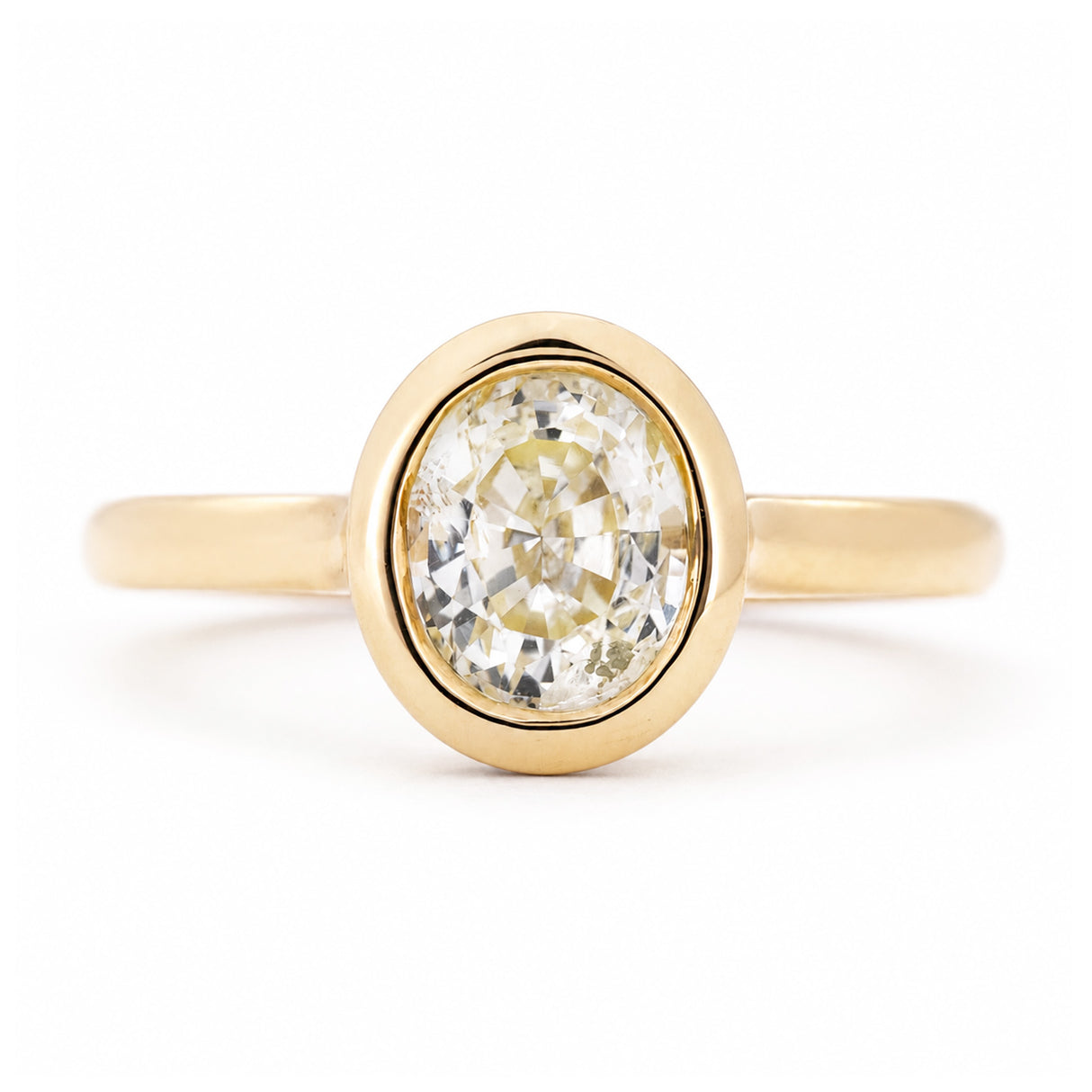An antique-inspired, pale yellow sapphire solitaire engagement ring set in yellow gold.