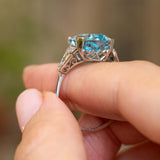 Profile view of an antique aquamarine and diamond ring, revealing the raised platinum setting and ornate openwork gallery.