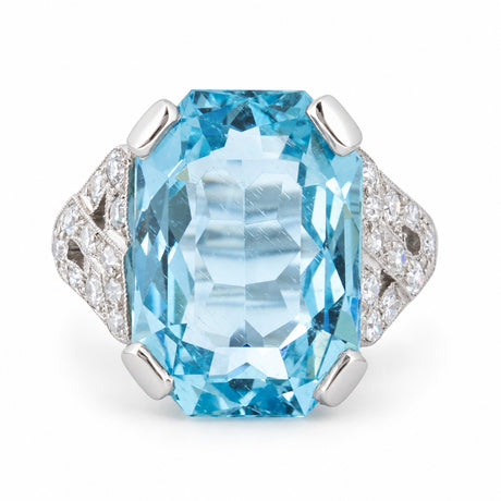 Front view of an antique Art Deco cocktail ring featuring an octagonal light blue aquamarine with round diamond shoulders in platinum.