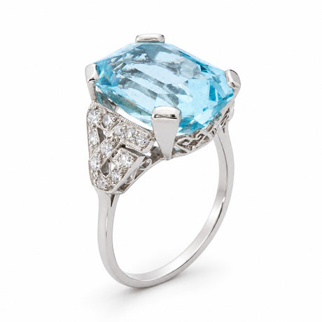 Angled product view of an antique aquamarine and diamond ring, showcasing its large octagonal gemstone and geometric platinum setting.