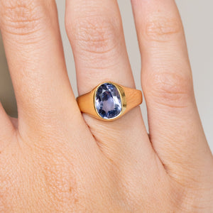 Close-up of the antique yellow gold ring, featuring a blue-violet sapphire within a smooth rub-over setting.