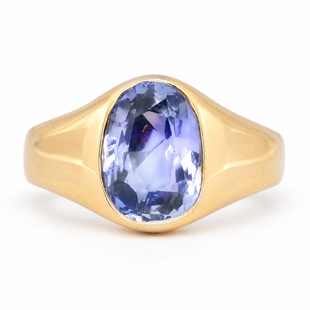 Antique Victorian Ceylon blue-violet sapphire solitaire engagement ring, rub-over set in sculpted yellow gold.