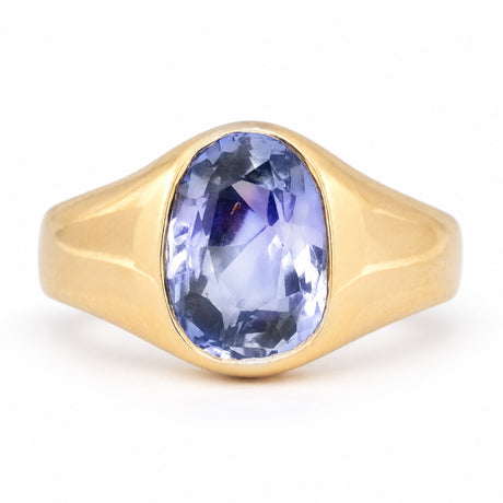Antique Victorian Ceylon blue-violet sapphire solitaire engagement ring, rub-over set in sculpted yellow gold.
