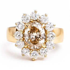 Vintage 1980s fancy coloured brown diamond cluster ring featuring an oval brown diamond surrounded by a sparkling cluster of brilliant-cut white diamonds in yellow gold.