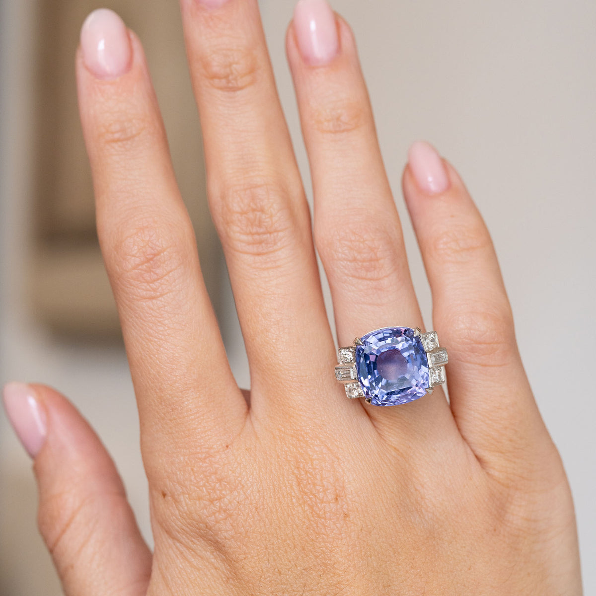 Vintage violet-blue sapphire and diamond ring worn on the hand, displaying its bold statement proportions.
