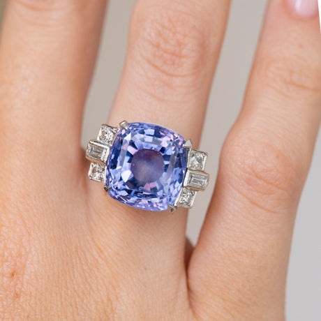 Close-up of the vintage platinum ring, with a large colour-change sapphire framed by stepped diamond-set shoulders.