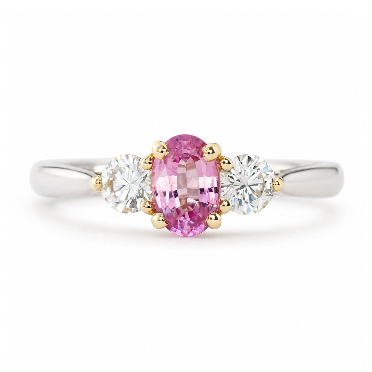 Vintage, 1990s pink sapphire and diamond three-stone engagement ring in platinum shown against a white background.