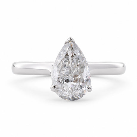 Front view of a vintage 1990s salt and pepper pear-cut diamond solitaire ring in polished white gold.