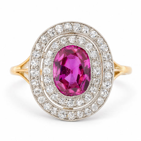 Antique Edwardian Burmese ruby and diamond cluster engagement ring in yellow gold and platinum, featuring an oval old-cut pinkish-red ruby surrounded by two concentric halos of sparkling diamonds.