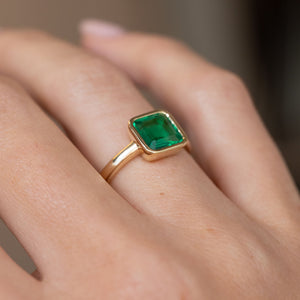 Natural side angle of the Colombian emerald engagement ring worn on the hand, revealing its clean, understated profile.