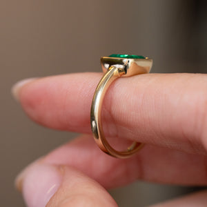 Profile detail of the antique-inspired Colombian emerald ring, showing the raised setting and slender yellow gold shank.