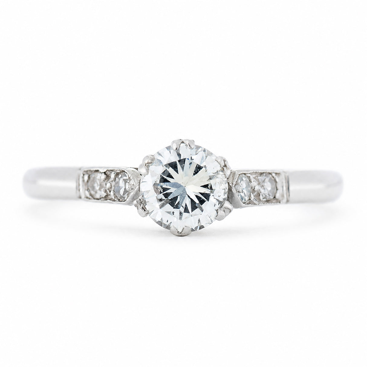 An antique ring from the Art-Deco period featuring a diamond at the centre flanked by smaller diamonds on the shoulders set in platinum.