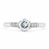 An antique ring from the Art-Deco period featuring a diamond at the centre flanked by smaller diamonds on the shoulders set in platinum.