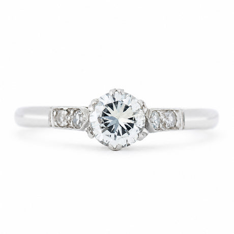 An antique ring from the Art-Deco period featuring a diamond at the centre flanked by smaller diamonds on the shoulders set in platinum.