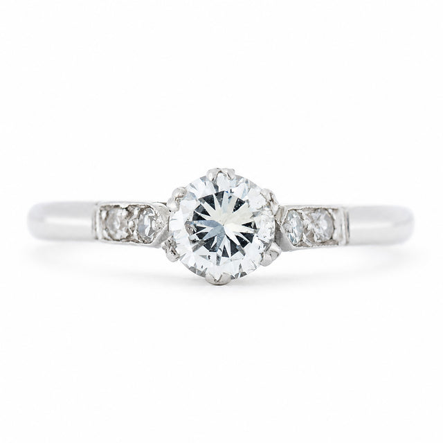 An antique ring from the Art-Deco period featuring a diamond at the centre flanked by smaller diamonds on the shoulders set in platinum.