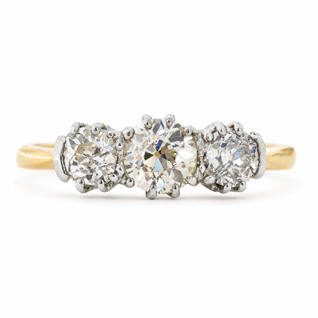An antique, Edwardian engagement ring with three old-cut diamonds with a yellow gold band. 