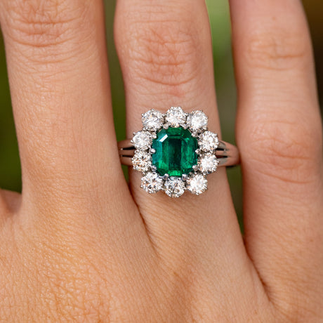 A close up detailed image of a Vintage, 1950s emerald and diamond cluster cocktail engagement ring white gold