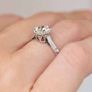 Side view on the hand revealing the raised claw setting and refined Art Deco platinum shoulders.