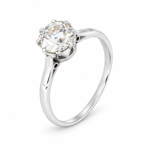 Elevated studio view of the antique diamond solitaire, showcasing its sculptural platinum setting and slender band.