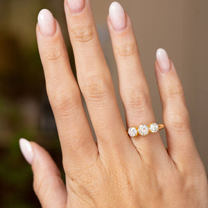 Vintage 1930s three-stone diamond ring worn on the hand, showing its graduated diamonds and warm 18ct yellow gold band.