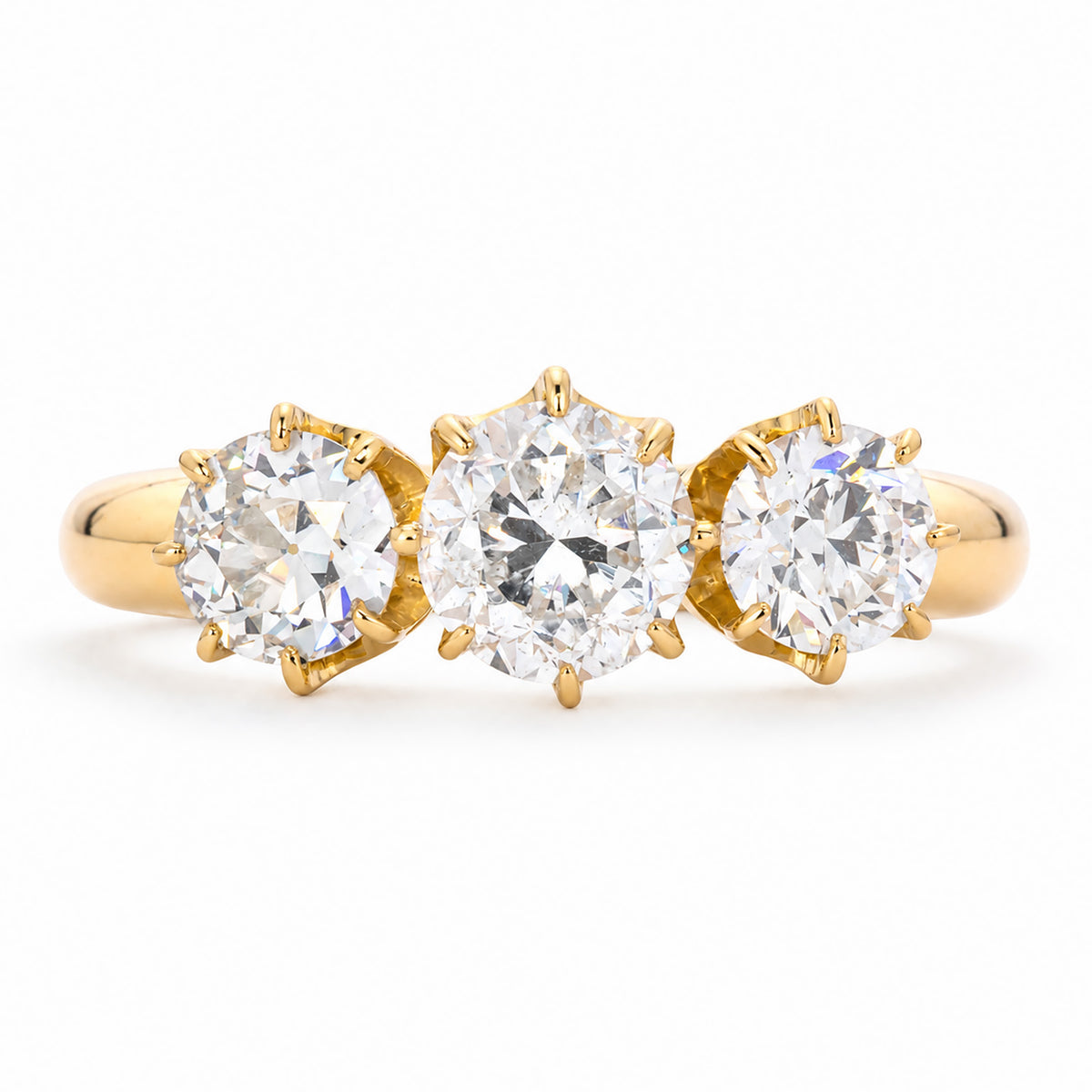 Front view of a vintage 1930s three-stone diamond engagement ring in 18ct yellow gold, with a transitional-cut centre diamond and old-cut diamond sides.