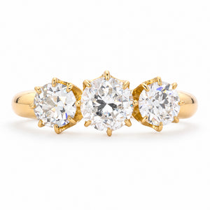 Front view of a vintage 1930s three-stone diamond engagement ring in 18ct yellow gold, with a transitional-cut centre diamond and old-cut diamond sides.